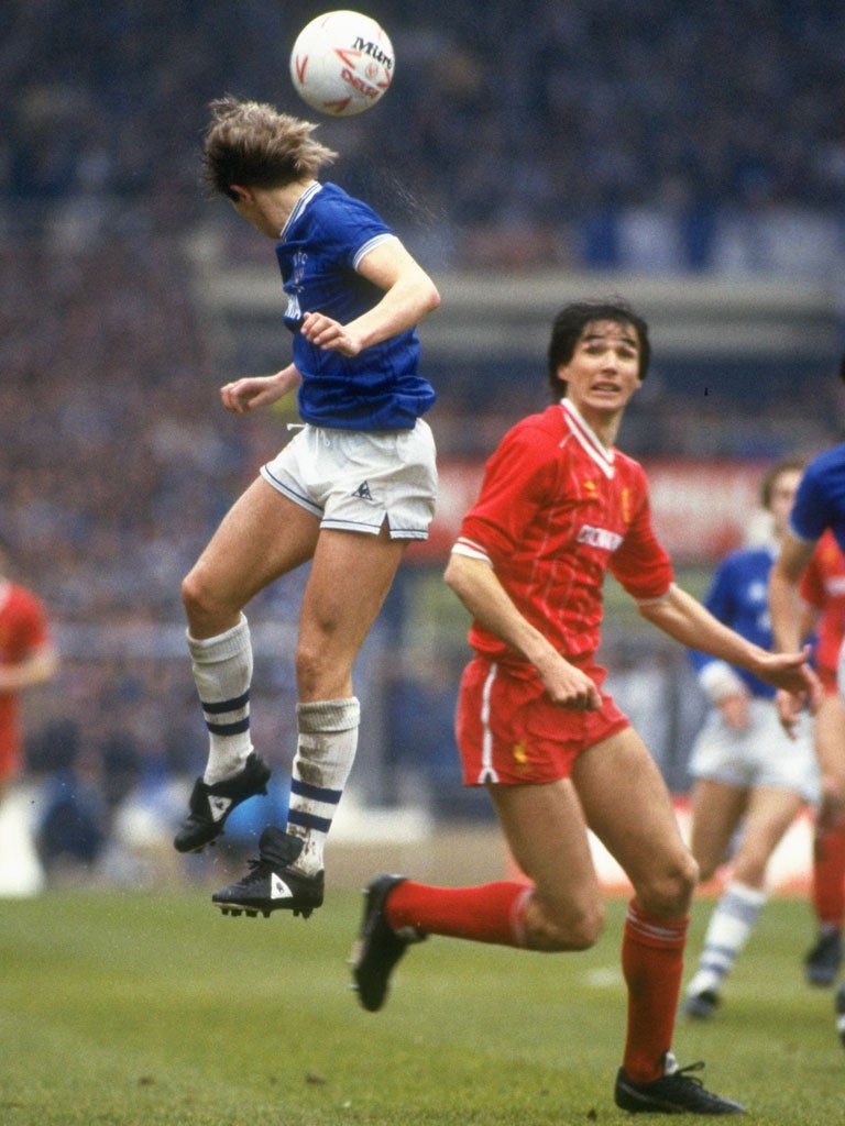 Everton's Adrian Heath heads the ball as Liverpool's Alan Hansen looks on during the 1984 Milk Cup