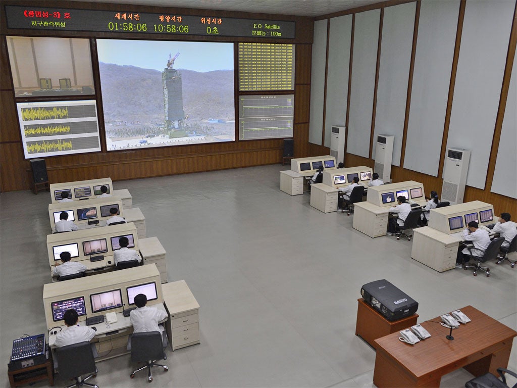 North Korean technicians at a control room in Pyongyang watch live images of the rocket Unha-3 as it is fuelled for take-off