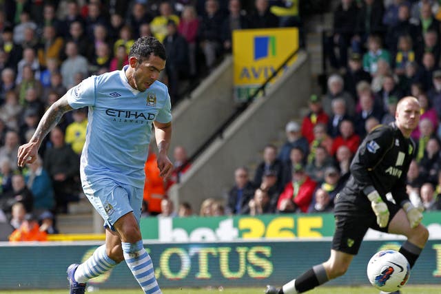 Carlos Tevez rounds Norwich City's goalkeeper John Ruddy to complete his hat-trick
