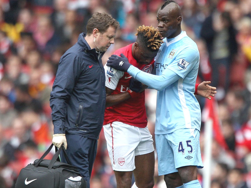 Mario Balotelli checks on Alex Song’s welfare after his dangerous studs-up challenge on the Arsenal midfielder, which went unpunished by the FA
