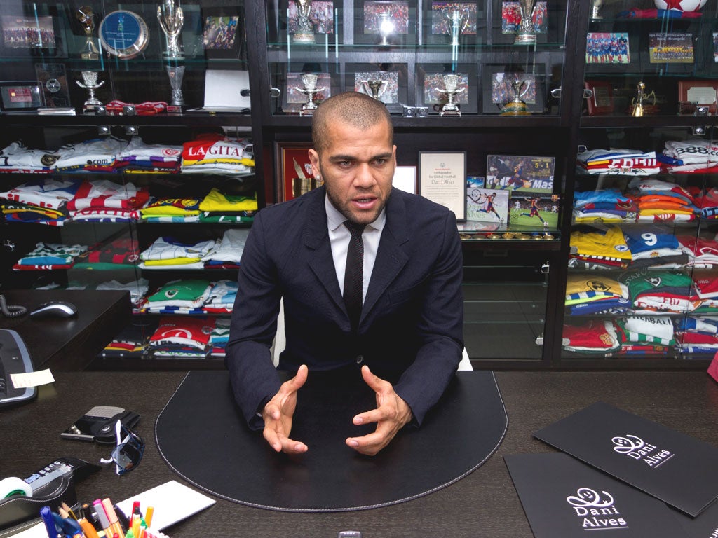 Dani Alves in his Barcelona office with his trophy haul and
shirts of his celebrated opponents