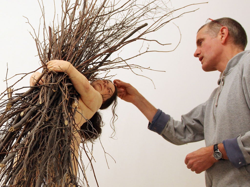 The artist Ron Mueck puts the finishing touches to Woman
with Sticks
