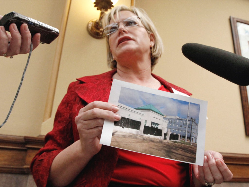 Terri Herring, an anti-abortion activist, holds a photograph of the abortion clinic in Jackson
