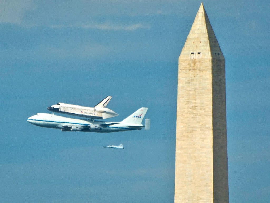 US space shuttle Discovery, sitting atop NASA's 747 shuttle carrier aircraft, flies over Washington monument yesterday