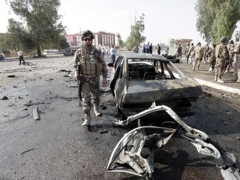 A Kurdish soldier patrols the site of the car bomb attack in Kirkuk
