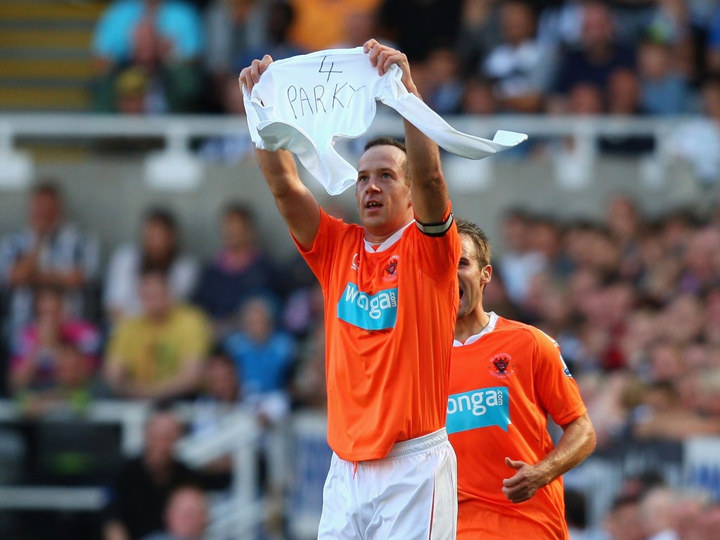 Charlie Adam holds up a '4 Parky' shirt after scoring for Blackpool in the 2-0 victory at Newcastle last season