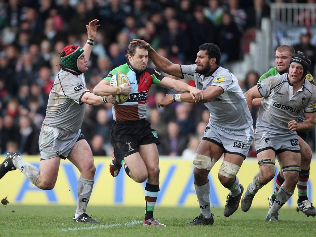 Nick Evans of Harlequins is tackled by Leicester's
Marcos Ayerza (left) and Steve Mafi