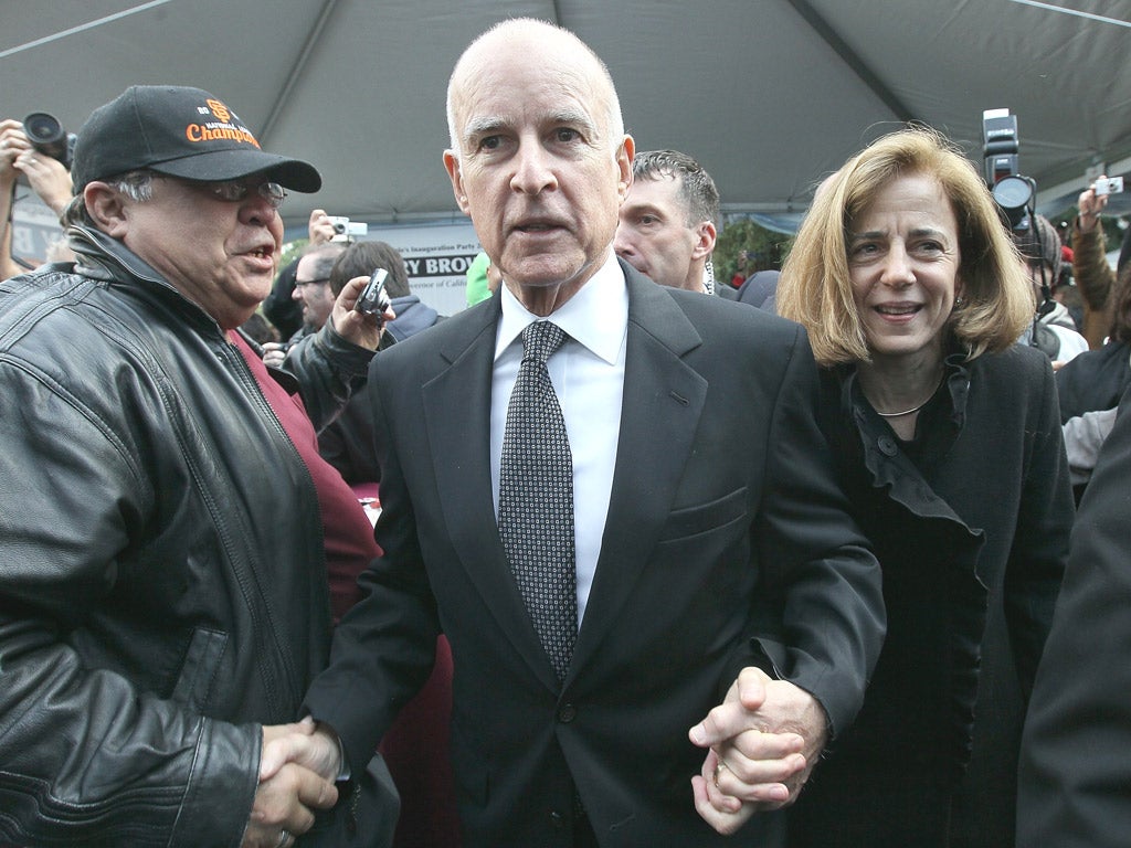 Jerry Brown, seen here with his wife Anne, is trying to reduce California’s huge and growing budget deficit