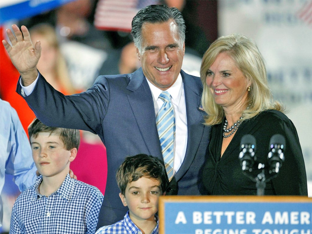 Mitt Romney waves with his wife, Ann, last night in New Hampshire after all but clinching the nomination