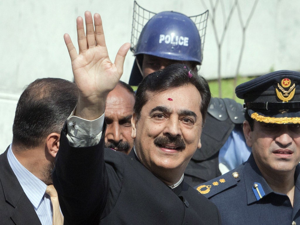 Yusuf Raza Gilani waves after arriving at the Supreme Court in Islamabad earlier today