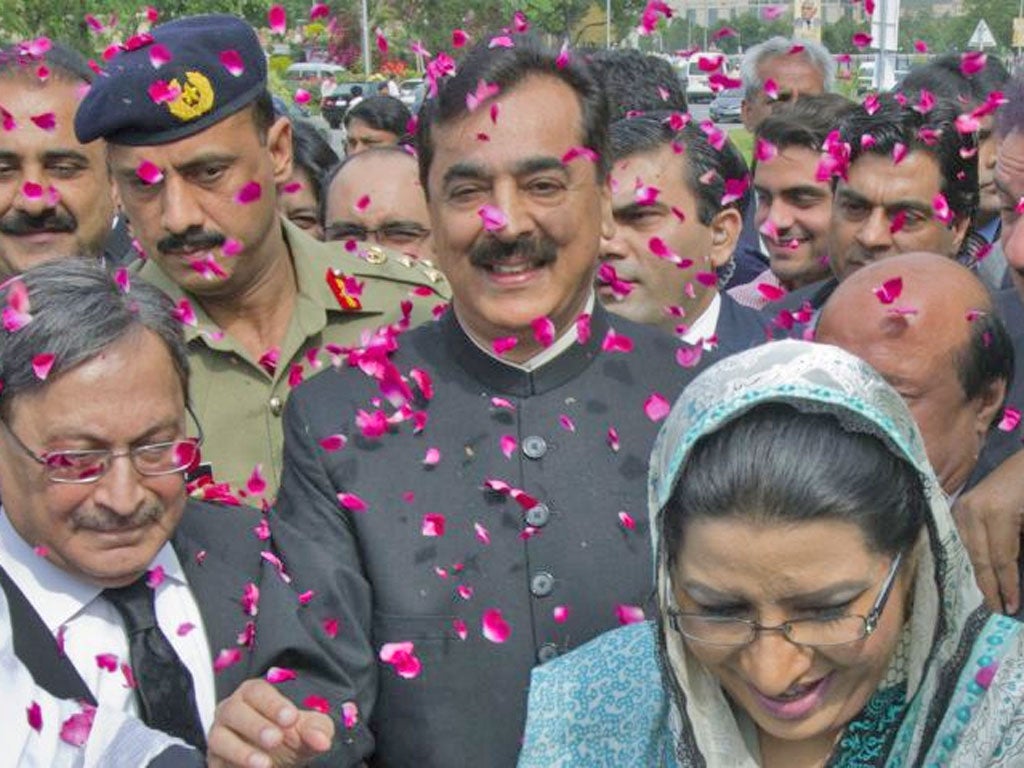 Supporters of Yousuf Raza Gilani shower him with petals as he arrives at court in Islamabad yesterday