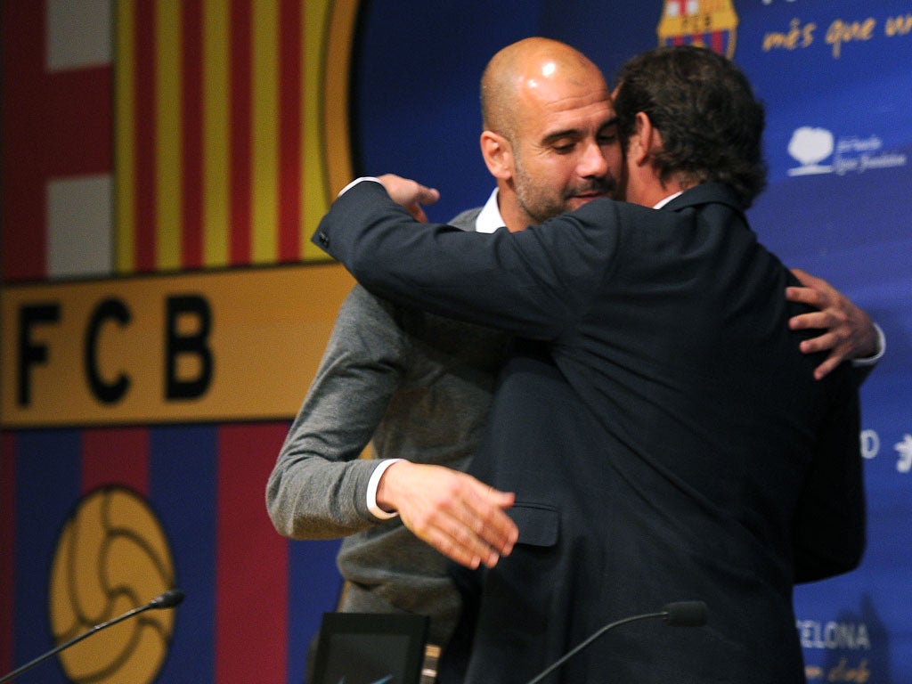 Barcelona's coach Josep Guardiola receives a hug from president Sandro Rosell during today's press conference