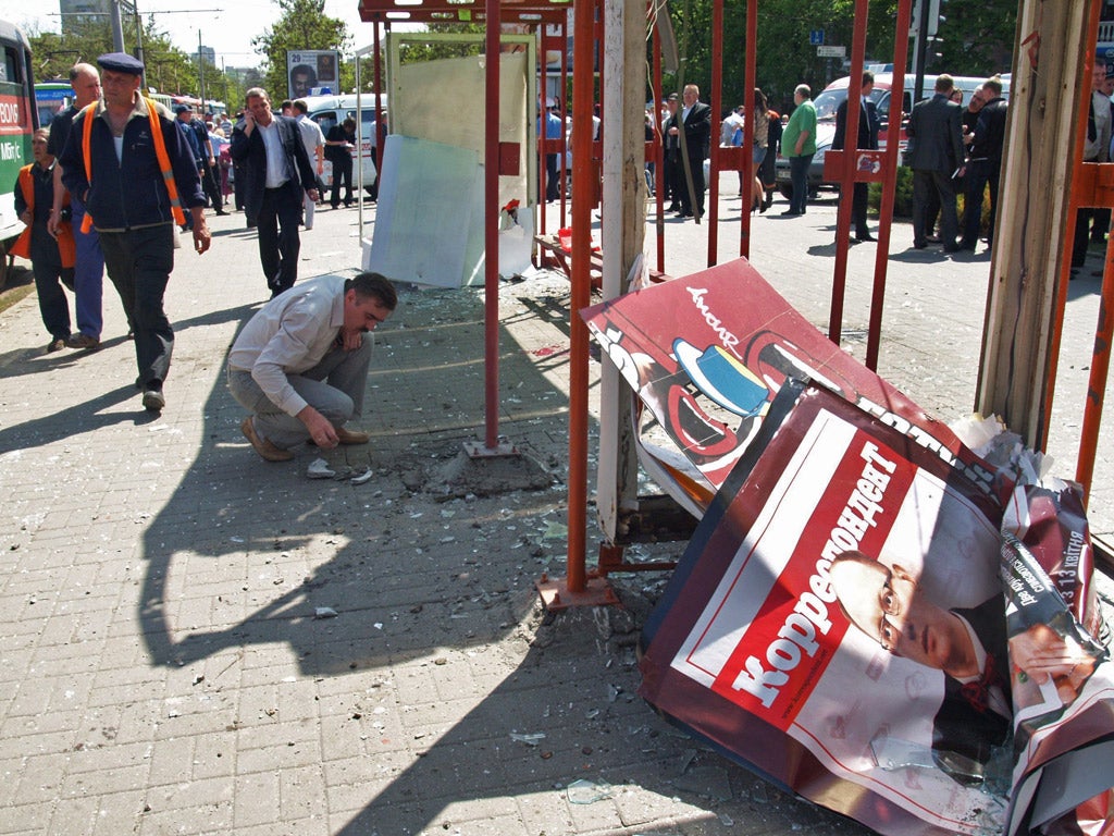 Ukrainian authorities examine the scene of an explosion at a tram stop in Dnipropetrovsk