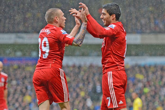 Red glow: Luis Suarez celebrates his Liverpool hat-trick at Carrow Road with fellow striker Craig Bellamy