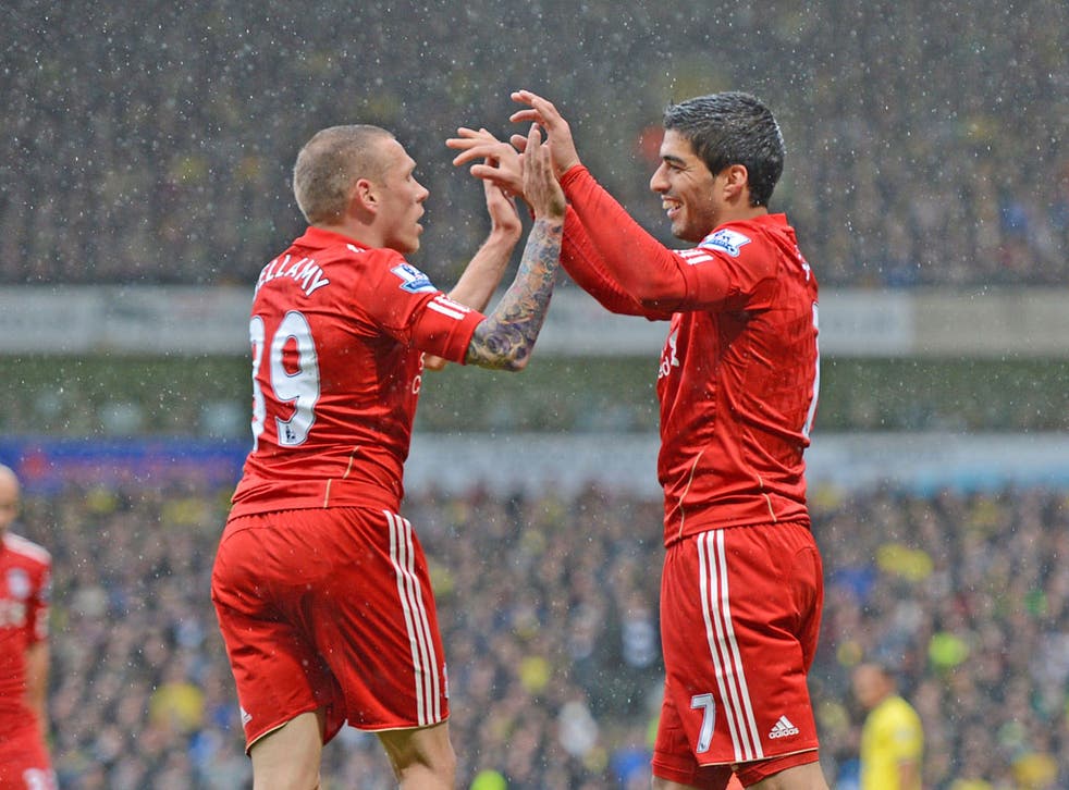 Red glow: Luis Suarez celebrates his Liverpool hat-trick at Carrow Road with fellow striker Craig Bellamy