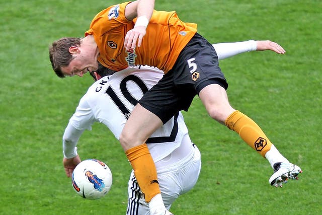 Ugly Swan: Danny Graham is all arms and legs as he loses a header to Wolves’ Richard Stearman during yesterday’s 4-4 draw at the Liberty Stadium