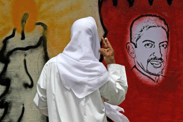 Protesters demand the release of Abdulhadi al-Khawaja, pictured on a street drawing