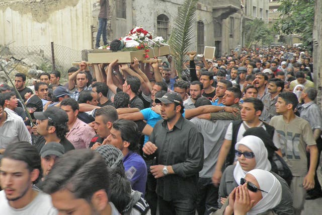 Anti-regime protesters carry the body of activist Nour al-Zahraa, 23, who was shot on Sunday