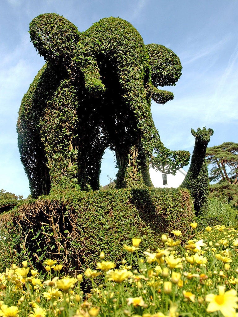 A green elephant stands guard over the Green Animals topiary garden besides a sculpted giraffe in Portsmouth