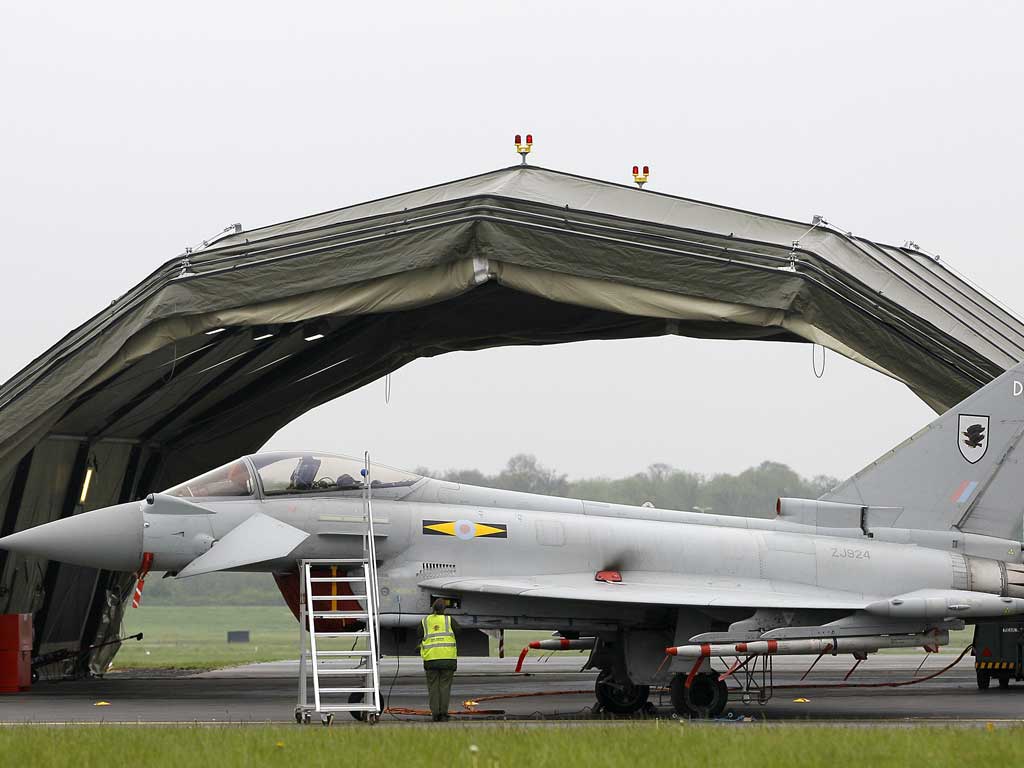 Ground technicians work on a Typhoon fighter aircraft at RAF base Northolt