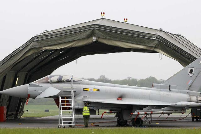 Ground technicians work on a Typhoon fighter aircraft at RAF base Northolt
