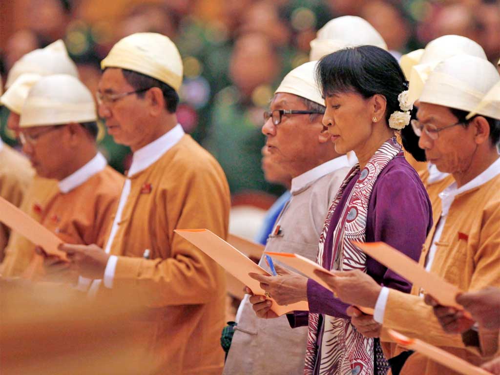 Aung San Suu Kyi, centre, and MPs from the National League for Democracy swear oaths in Burma's parliament in Naypyitaw yesterday