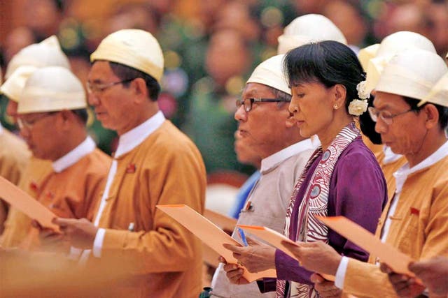 Aung San Suu Kyi, centre, and MPs from the National League for Democracy swear oaths in Burma's parliament in Naypyitaw yesterday