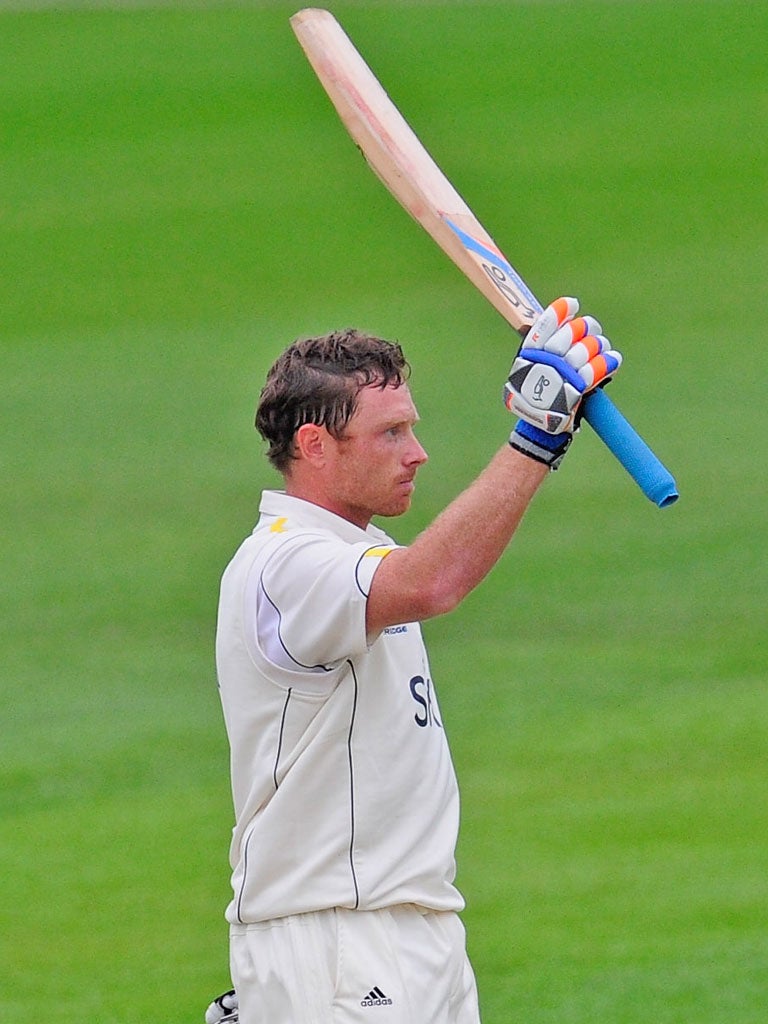 Warwickshire’s Ian Bell raises his bat after completing his century against Durham yesterday