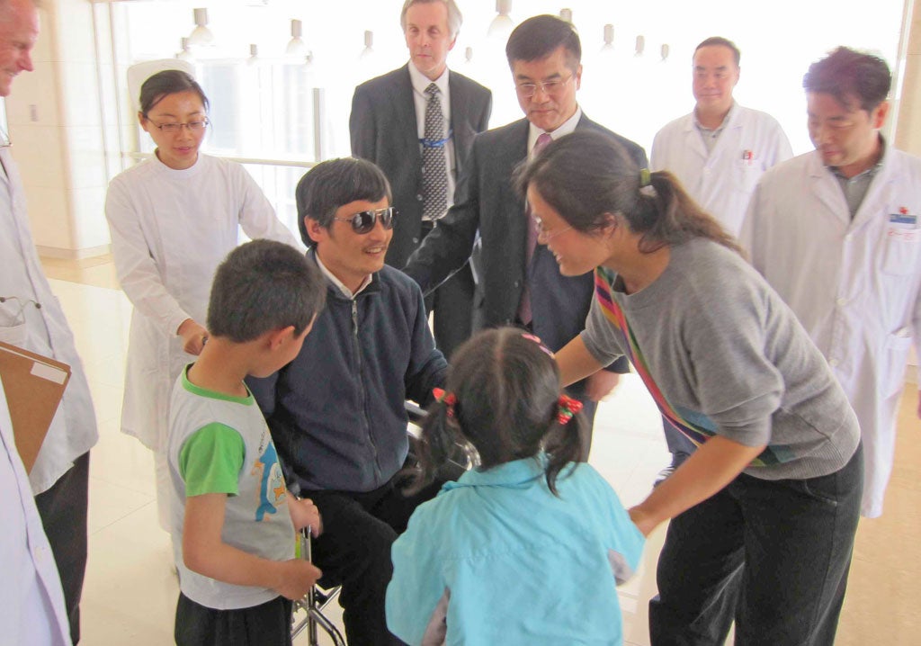 Activist Chen Guangcheng speaks to his wife Yuan Weijingand children in hospital as US ambassador Gary Locke (third right) looks on. He wants to
leave China for the US with Secretary of State Hillary Clinton