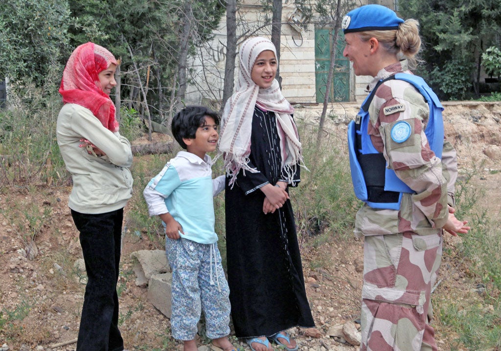 A UN observer speaks with Syrian children in the central province of Homs