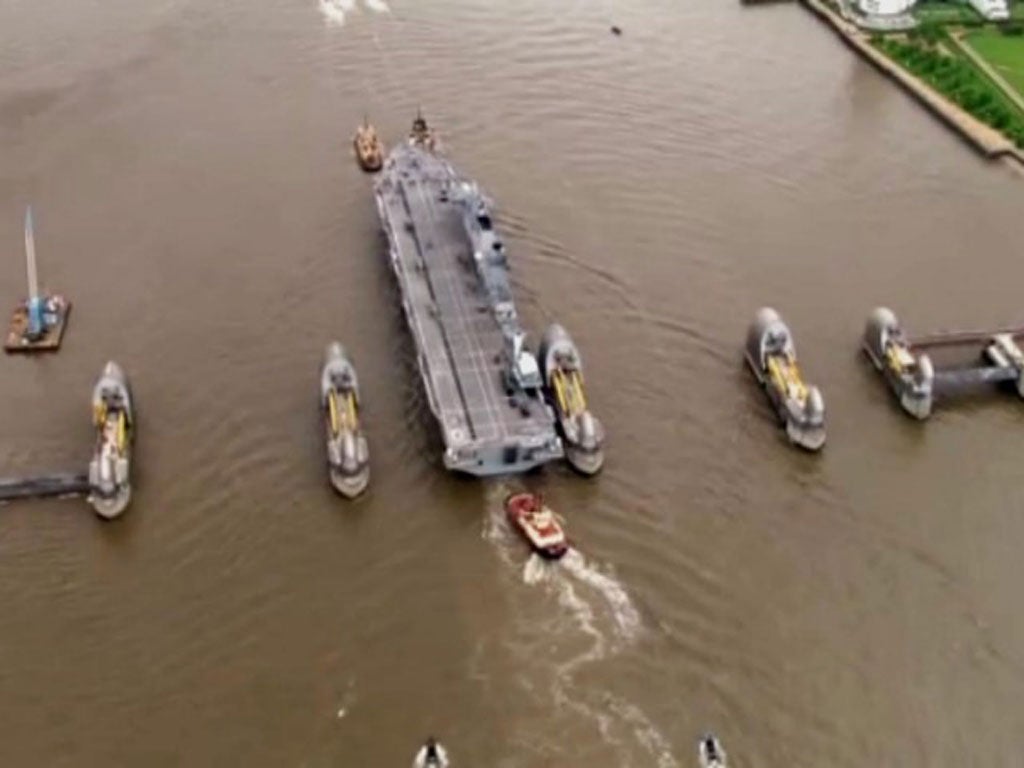 HMS Ocean narrowly misses the Thames Barrier guided by three tug boats