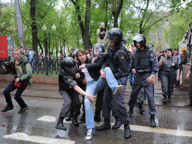 Police officers detain an anti-Putin protester in Moscow today