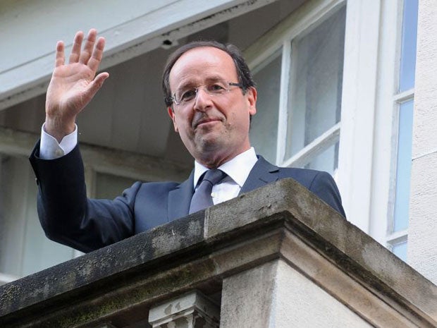 Francois Hollande waves from the balcony of the Socialist Party headquarters today