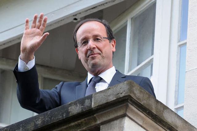 Francois Hollande waves from the balcony of the Socialist Party headquarters today