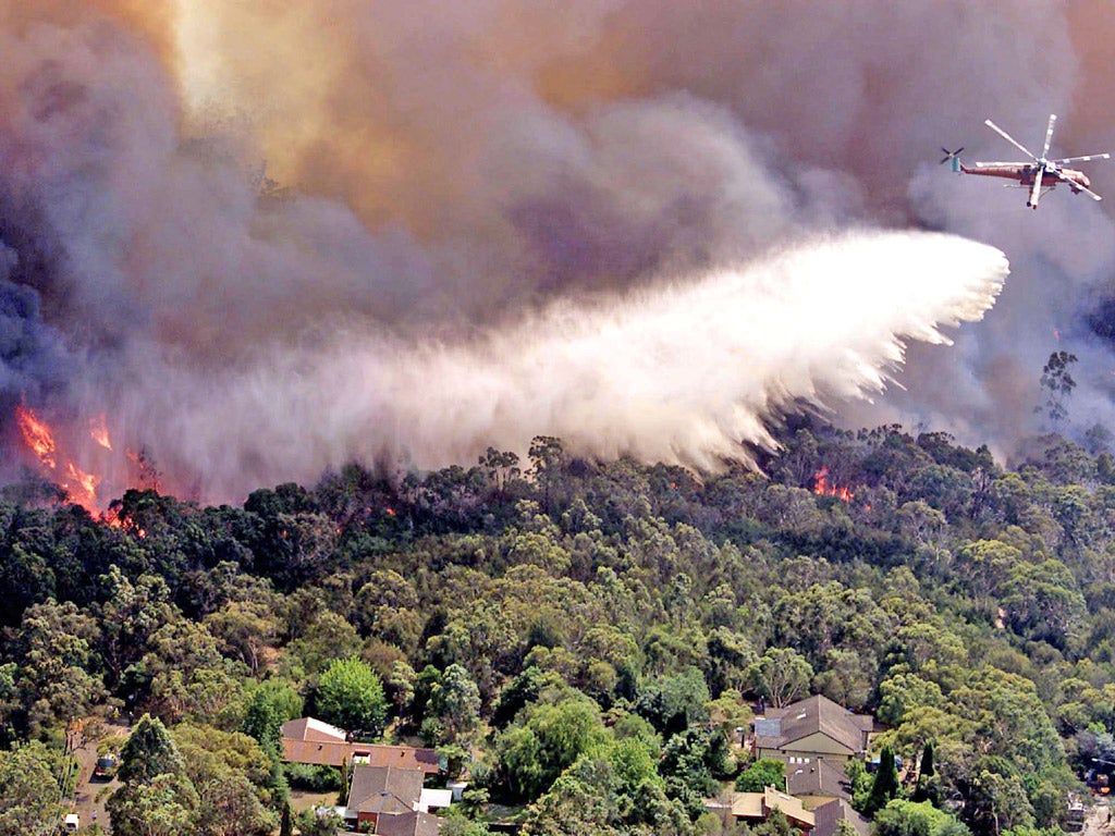 A giant helitanker drops 9,500 liters of water on fires as they threaten homes at North Epping, on the suburb of Sydney in January 2002