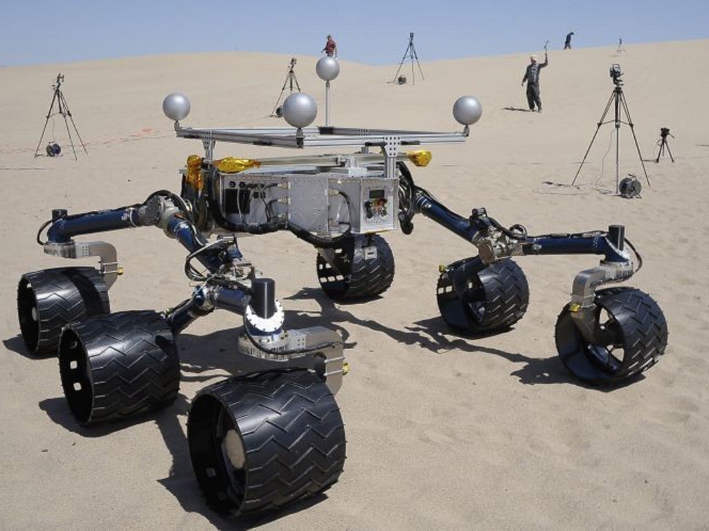 Members of the Mars Science Laboratory/Curiosity team, which includes rover drivers and scientists, test out an engineering model of its next generation Mars rover, dubbed "Curiosity"