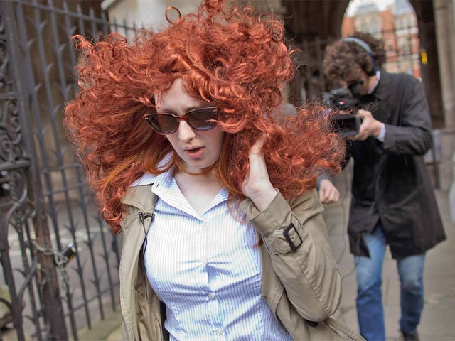 A flame-haired Rebekah Brooks look-a-like does her worst to avoid the paparazzi outside the High Court yesterday