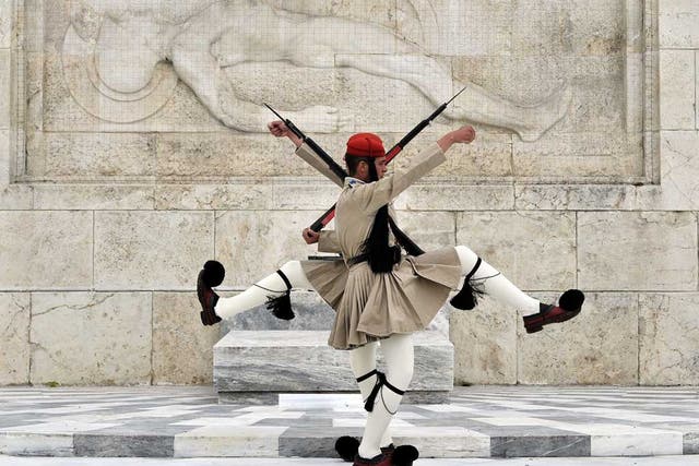 Greek Presidential guards perform in front of the tomb of the Unknown soldier in central Athens