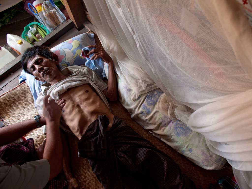 Powerless to resist: A TB patient is treated at his home in Yangon, Burma, which relies on foreign aid for about half its resources to fight the disease
