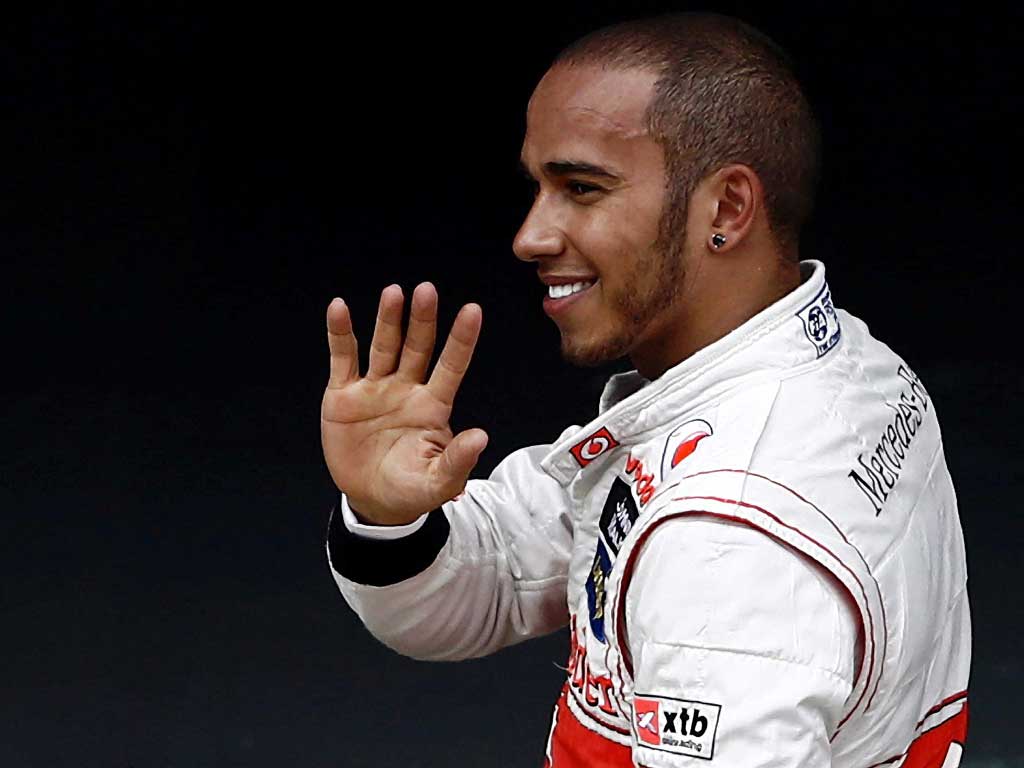 Before the storm: Lewis Hamilton acknowledges his fans after taking pole position but later stewards put an end to his jubilation with a heavy punishment