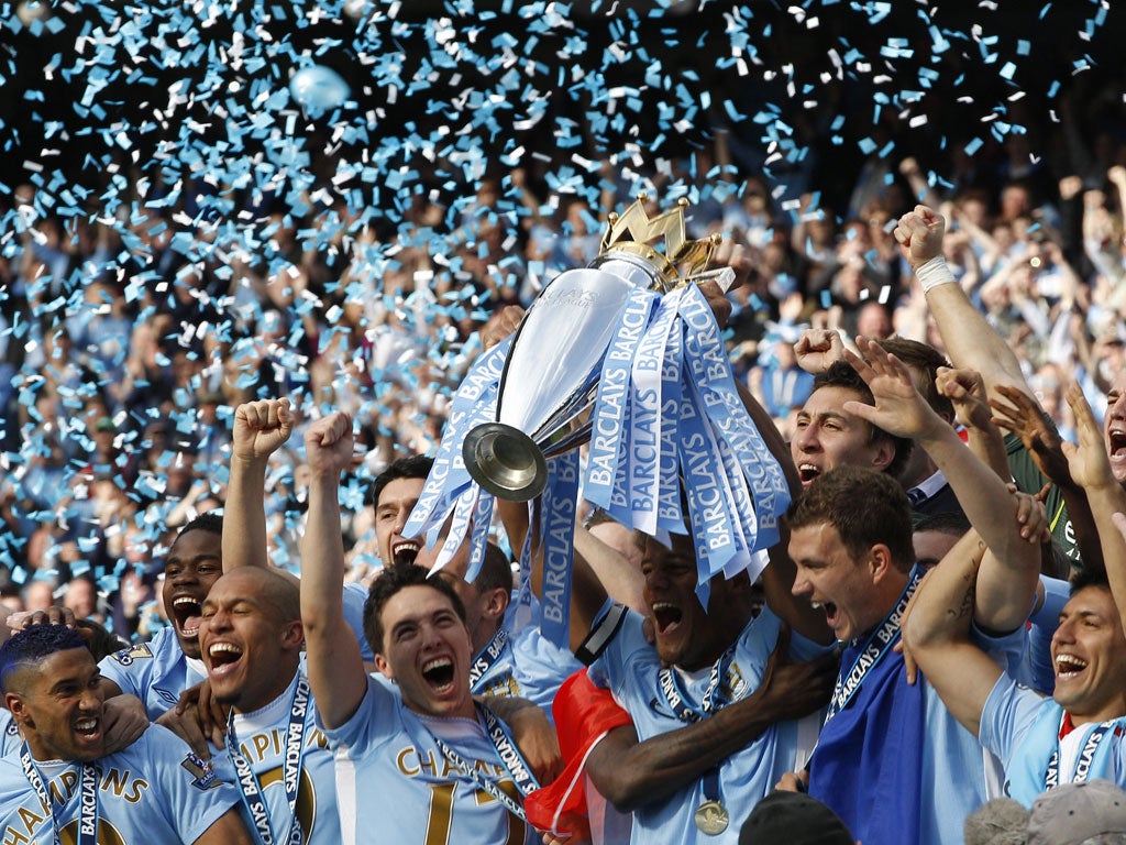 May 13, 2012: Manchester City captain Vincent Kompany lifts the English Premier League trophy following their soccer match against Queens Park Rangers at the Etihad Stadium in Manchester, northern England.