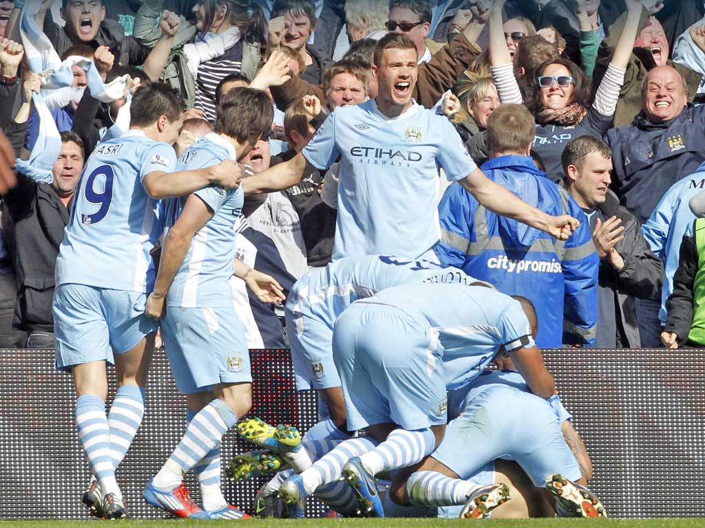 Sergio Aguero (hidden) is mobbed after scoring the barely believable
94th-minute winner which handed City the League title