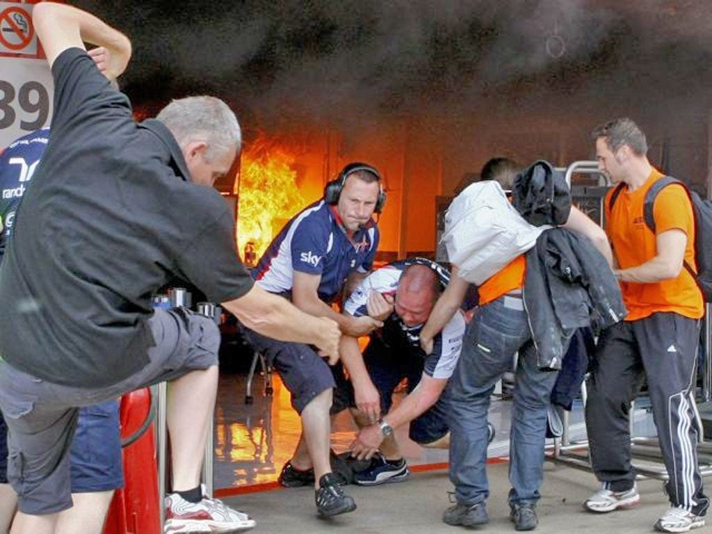Williams’ mechanics pull a colleague free of the blazing garage