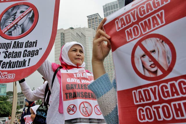 Protesters hold up anti-Gaga posters during a Muslim rally against her concert in Jakarta