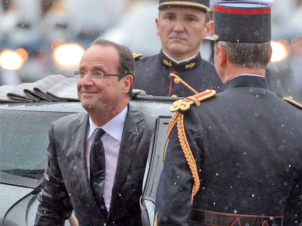 Rain pours down as Hollande arrives at the Arc de Triomphe as part of the new President's inauguration ceremony