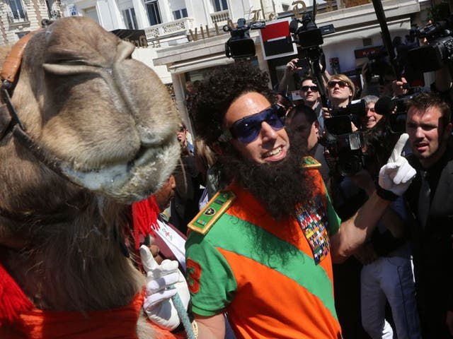 Sacha Baron Cohen dressed as Admiral General Aladeen poses with a camel in Cannes
