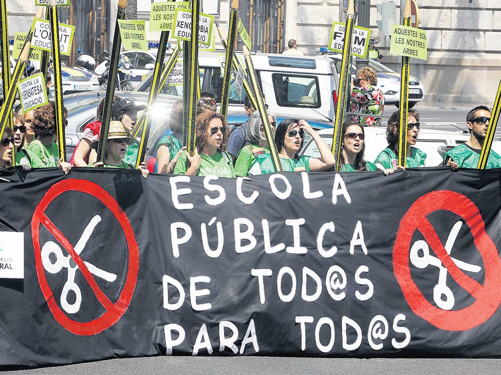 Protesters in Valencia hold giant pencils and a banner protesting against Spain’s education cuts, during a
teachers’ strike