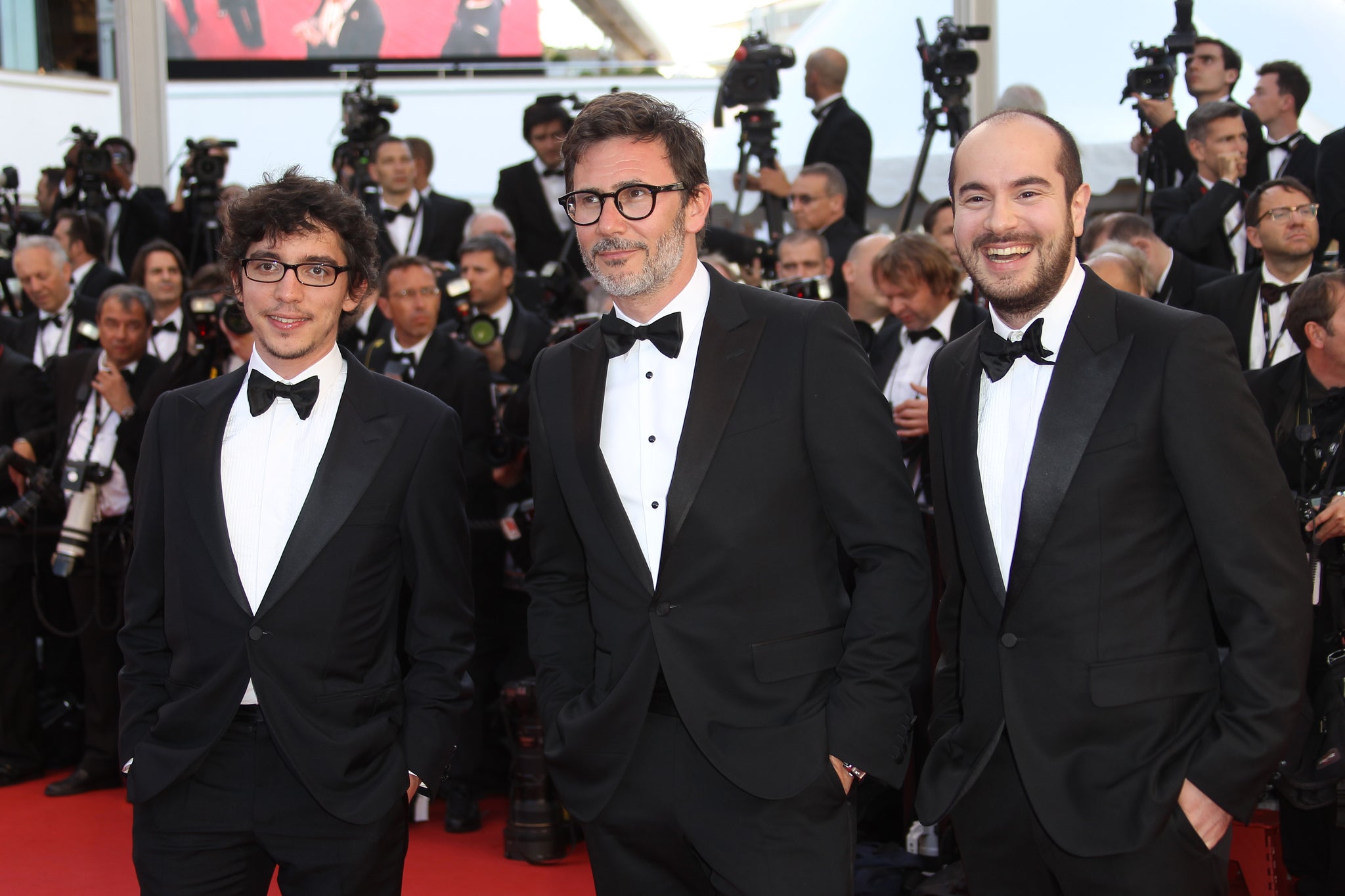 French director Michel Hazanavicius (C) arrives with French Kyan Chojandi (L) and actor Bruno Muschio for the screening of 'Moonrise Kingdom' and the opening ceremony of the 65th Cannes film festival on May 16, 2012 in Cannes.