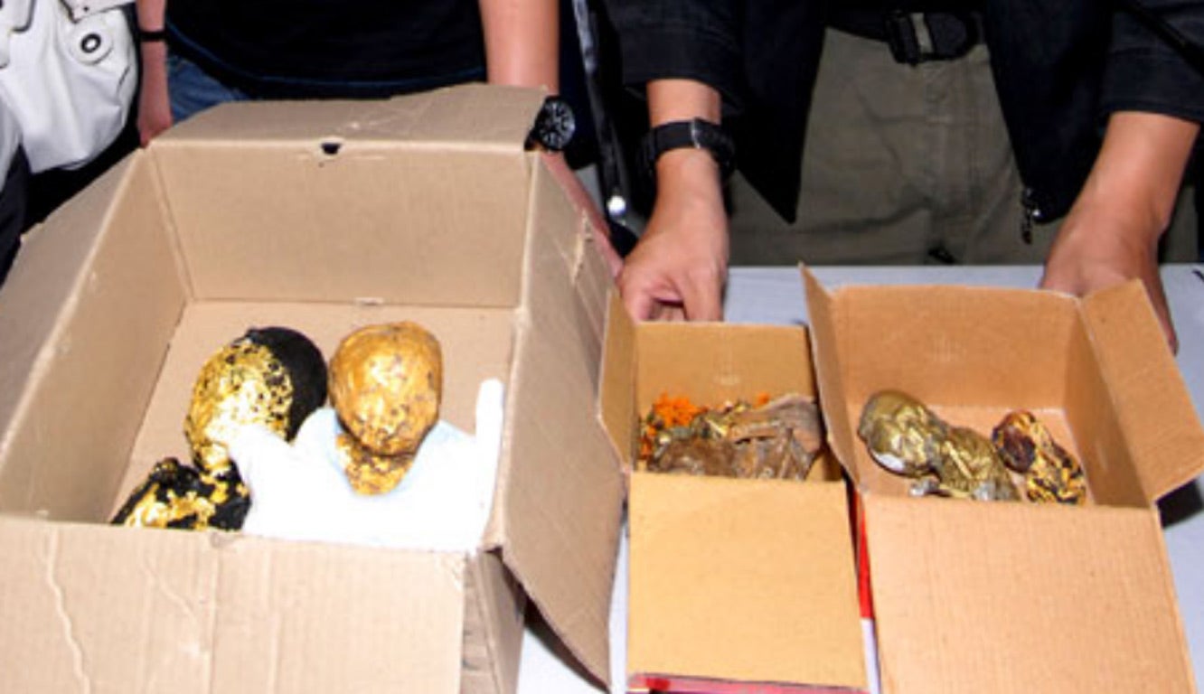 Thai police show the remains of six foetuses wrapped in gold leaf