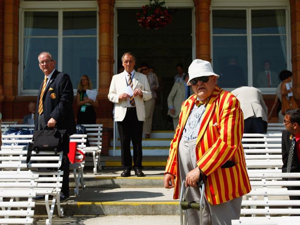 MCC members look on from Lord's pavilion, resplendent in the
club's egg-and-bacon stripes